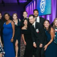 Group of guests posing in front of the Enrichment stage.